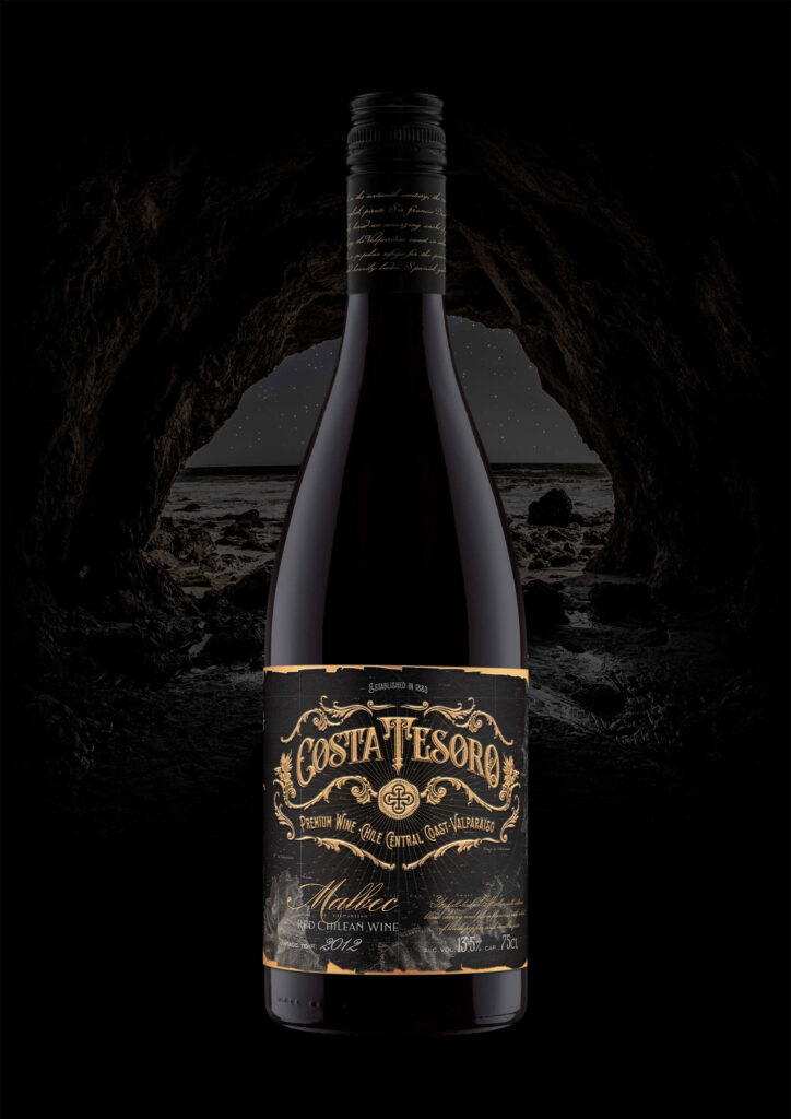 Black bottle with a Costa Tesoro label against a dark image of a cave
