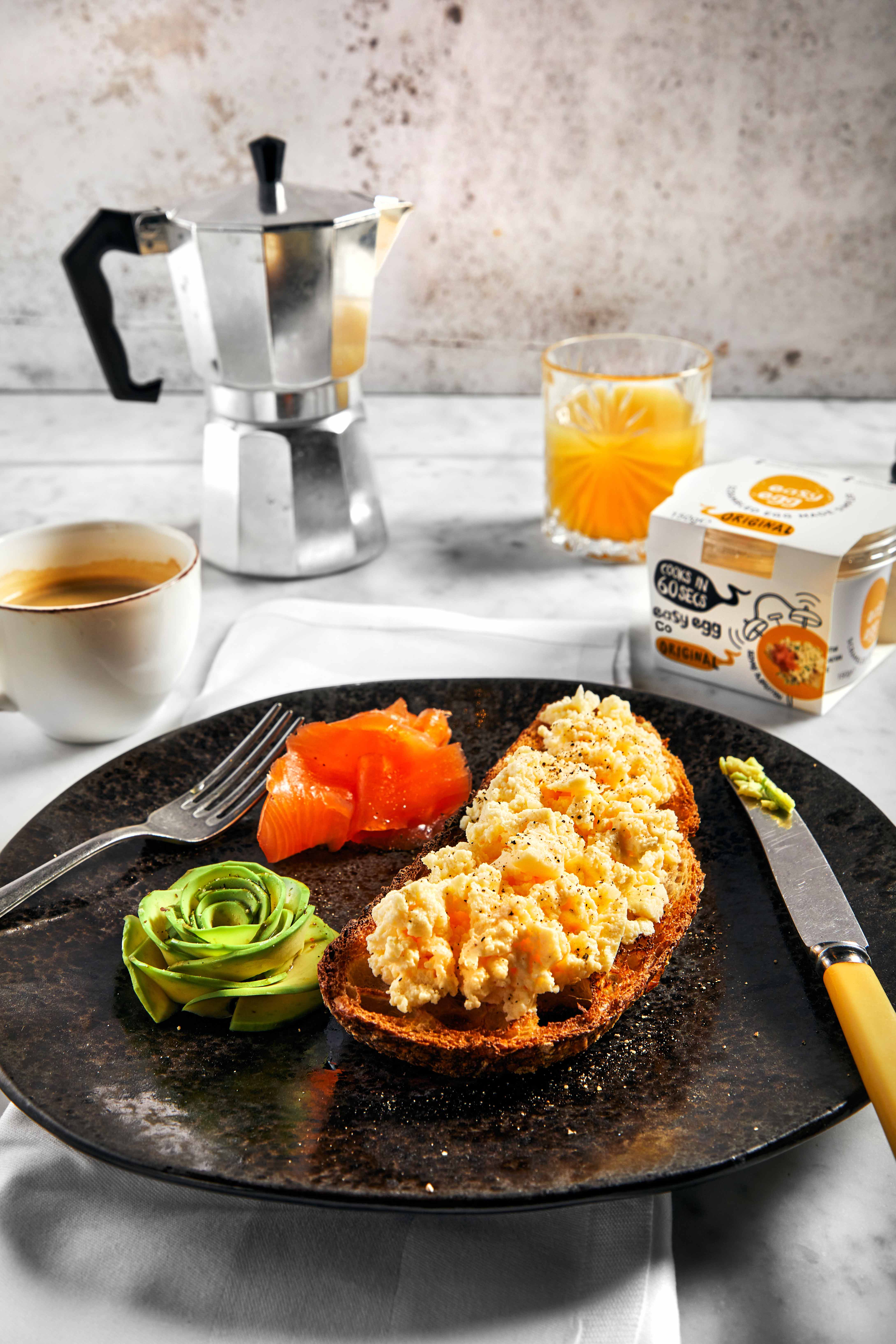 Plate of scrambled egg and smoked salmon with egg pot packaging