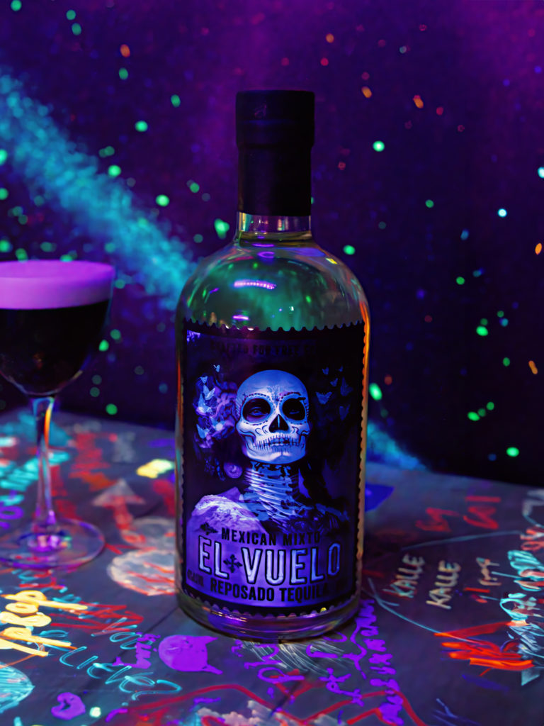 A bottle of El Vuelo, featuring a label design inspired by the journey to the afterlife, alongside an espresso martini looking cocktail