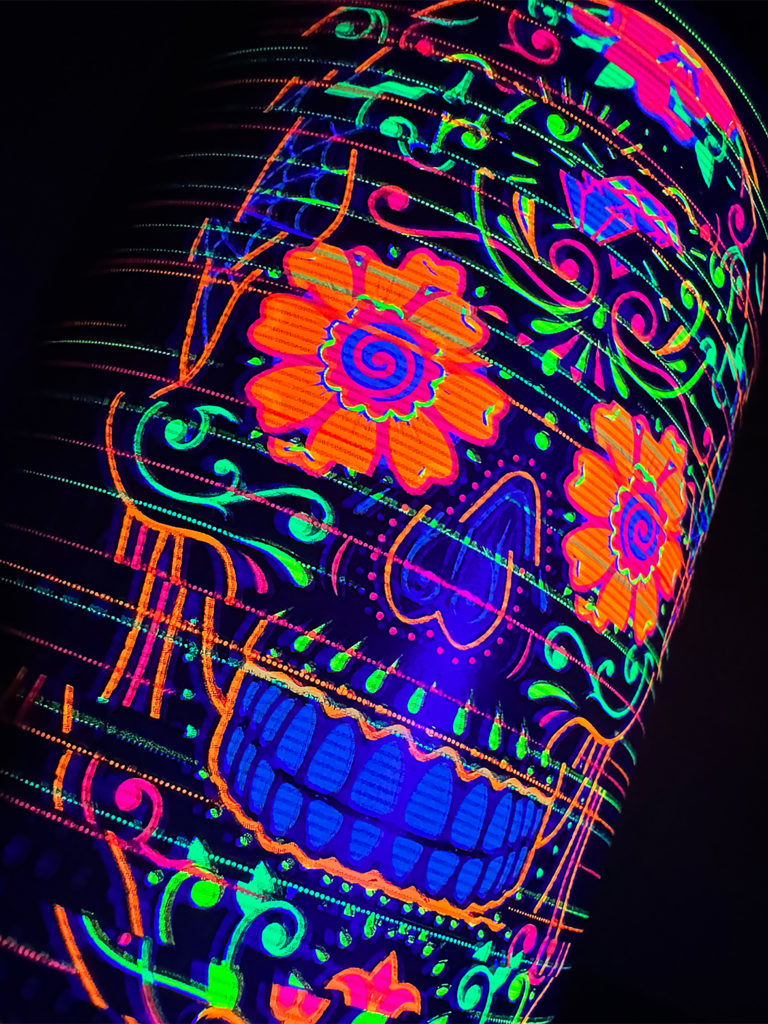A close up of the Alive By Night hero label featuring a sugar skull inspired by Day of the Dead, made up of five UV foils